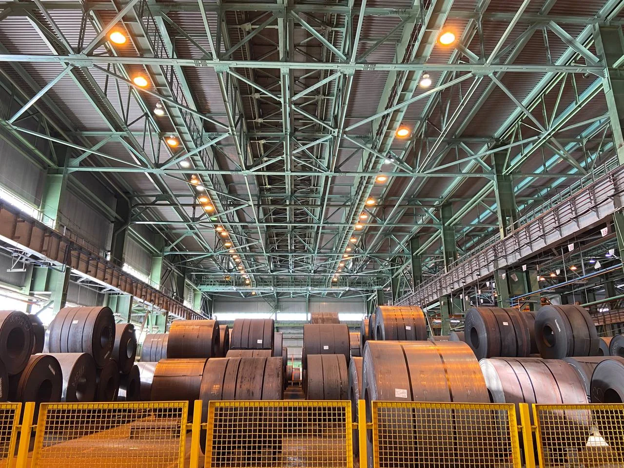Industrial steel facility with structural steel roof framing and steel coils